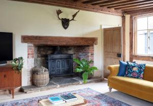 a living room with a fireplace and a couch at Brook Farm in Harleston