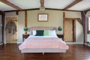 a bedroom with a large bed with a pink bedspread at Brook Farm in Harleston