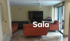 sala de estar con sofá y TV en Casa Paseos del Sol en Las Cardenas