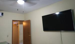 TV de pantalla plana colgada en la pared en Casa Paseos del Sol en Las Cardenas