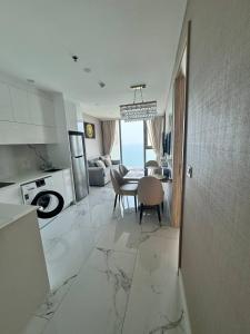 喬木提恩海灘的住宿－Copacabana Beach Jomtien，厨房、带桌子的客厅和用餐室