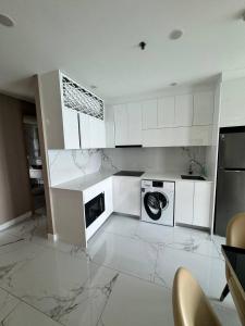 a kitchen with white cabinets and a washer and dryer at Copacabana Beach Jomtien in Jomtien Beach