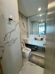 a bathroom with a sink and a toilet and a mirror at Copacabana Beach Jomtien in Jomtien Beach