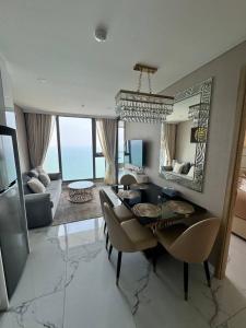 a living room with a dining table and a mirror at Copacabana Beach Jomtien in Jomtien Beach