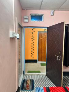 an open door to a room with orange doors at Sweet Home Lodge in Guwahati