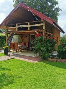 a house with a patio with a table and chairs at Domek nad jeziorem in Klepnica