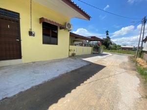 a yellow building with a door on the side of a road at KZ Roomstay in Kuala Terengganu