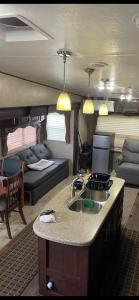 a kitchen and living room with a couch and a sink at Entire 1bedroom RV Camper in Fort Pierce