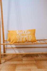 Una almohada amarilla con las palabras sonriendo en ella en Sibylla Studio Deluxe, en Kalymnos