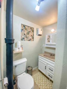 a bathroom with a white toilet and a sink at 2 bed 1 bath cottage home in Price