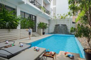 a woman standing next to a swimming pool in a building at Angkor Aurora in Siem Reap