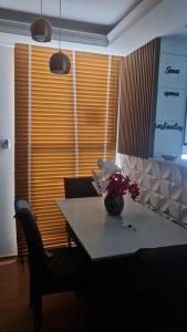 a dining room table with a vase of flowers on it at Apartament litoral norte NatalRN in Natal