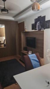 a living room with a table and a tv at Apartament litoral norte NatalRN in Natal