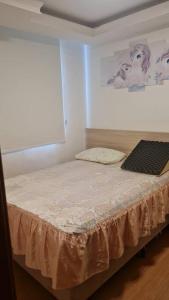 1 dormitorio con 1 cama con ordenador portátil en Apartament litoral norte NatalRN en Natal