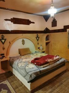 a bedroom with a large bed with an arched ceiling at Riad family in Merzouga