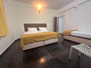 1 dormitorio con 2 camas y mesa. en MPS Sai Palace, en Tiruvannāmalai