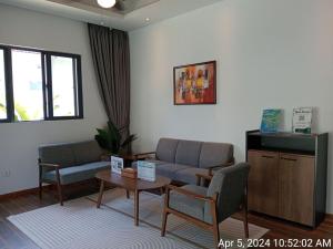 uma sala de espera com um sofá, cadeiras e uma mesa em Ream YoHo Resort em Sihanoukville