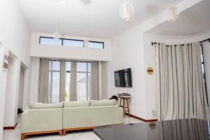 ein Wohnzimmer mit einem Sofa und einem TV in der Unterkunft T&T Apartment in Ndola