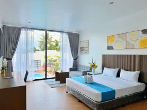 a bedroom with a large bed and a living room at Grand Palmera Hotel in General Santos