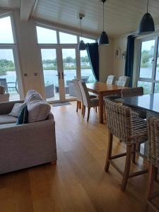 een woonkamer met een bank en een tafel en stoelen bij Tarka Halt 1 - Haven Lakeland Leisure in Flookburgh