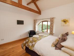 a bedroom with a large bed and a window at Dairy Cottage in Staintondale