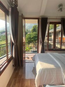 a bedroom with a bed and a large window at Peaceful MaiChau Homestay in Mai Chau