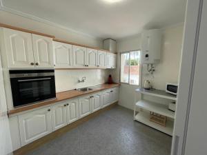 une cuisine avec des armoires blanches et un évier dans l'établissement Casa Santiago de Ribera, Murcia - Blue Sky Property, à Santiago de la Ribera