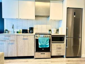 a kitchen with a stove and a refrigerator at Cozy Condo Near EatonCentre Mall in Toronto