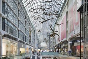 a shopping mall with birds hanging from the ceiling at Cozy Condo Near EatonCentre Mall in Toronto