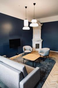 uma sala de estar com um sofá e duas cadeiras e uma televisão em Ineon Hotel em Turku
