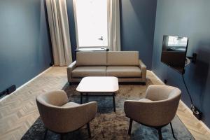 uma sala de estar com um sofá e duas cadeiras e uma mesa em Ineon Hotel em Turku
