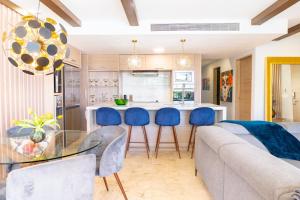 ein Wohnzimmer mit einem Glastisch und blauen Stühlen in der Unterkunft Elements 214 condo in Playa del Carmen