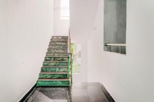 a staircase in a white room with green paint at OYO Flagship RBS Residency in Maula Ali
