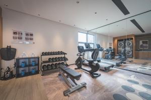 a gym with several treadmills and a mirror at UrCove by HYATT Nanjing Downtown in Nanjing