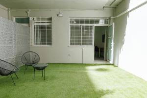 Snug studio apartment with pvt garden access I في أثينا: غرفه فاضيه فيها كرسيين وعشب اخضر
