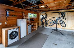 a garage with a washing machine and two bikes on the wall at Aura @ Home in Rotorua