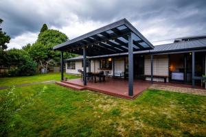 a pavilion with a table on a deck in a yard at Aura @ Home in Rotorua