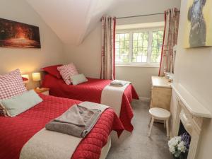 1 dormitorio con 2 camas y ventana en Glenside en Far Sawrey