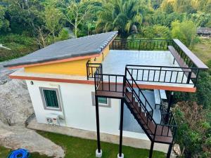 a small house with a roof with two spiral stairs at Lamtam Maesa Resort ลำธารแม่สา รีสอร์ท in Mae Rim