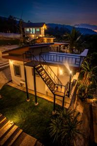 a house with a staircase on top of it at night at Lamtam Maesa Resort ลำธารแม่สา รีสอร์ท in Mae Rim