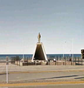 una estatua frente a la playa con el océano en Wonderful house en Puerto Madryn