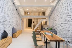 a dining room with a brick wall and tables and chairs at Meander 1948 in Taipei