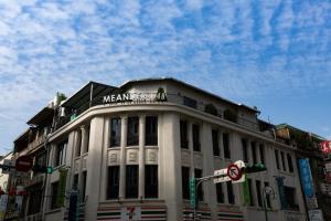 a white building with a sign on top of it at Meander 1948 Hostel - Taipei Main Station in Taipei