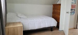 ein Schlafzimmer mit einem weißen Bett und einer Holzkommode in der Unterkunft Casa en Lautaro in Lautaro