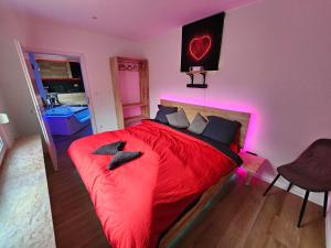 a bedroom with a red bed with pink lights at L'Appart Spa, Jacuzzi & Sauna in Differdange