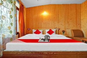 a bedroom with a bed with a telephone on it at OYO Hotel Jay Palace in Srinagar