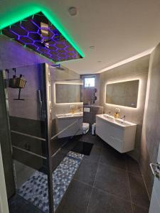 a bathroom with two sinks and a shower at L'Appart Spa, Jacuzzi & Sauna in Differdange