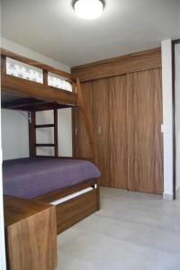 a bedroom with two bunk beds and wooden cabinets at Casa Lidia in Las Juntas +8 photos