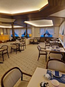 uma sala de jantar cheia de mesas e cadeiras em Hotel Meeresfriede em Cuxhaven