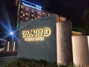 um sinal para um hotel em frente a um edifício em Tamarind Garden Hotel - SHA Plus Certified em Rayong
